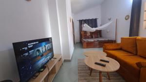 a living room with a couch and a tv and a table at DAVADI loc in Cotonou