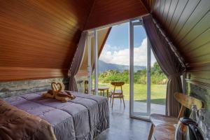a bedroom with a bed and a large window at Pandawa Glamping Kintamani in Bangli