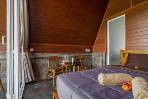 a bedroom with a bed and a table and chairs at Pandawa Glamping Kintamani in Bangli