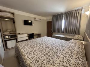 a hotel room with a bed and a tv at Atibaia Residence Hotel & Resort in Atibaia