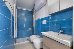 a blue bathroom with a toilet and a sink at Bel Horizonte 7 in Capoliveri