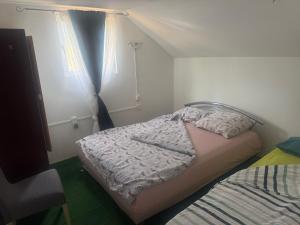 a small bedroom with a bed and a window at Horse Garden in Valea Groşilor