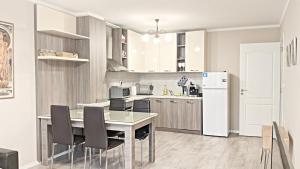 a kitchen with a table and chairs and a refrigerator at Lux 2 Central Apartment with Garage in Plovdiv