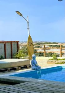 a statue sitting on the edge of a pool at Casa Villa Alive - Vichayito Sur, Los Organos Talara in San Martín