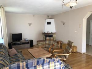 a living room with a couch and chairs and a tv at Apartament Zielone Buki in Buczkowice
