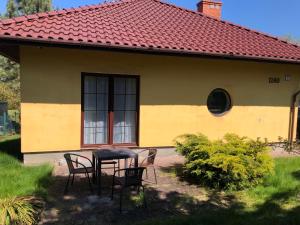 a table and chairs in front of a house at Apartament Zielone Buki in Buczkowice
