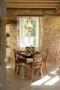 a dining room with a table and chairs and a window at La Petite Noble in Commentry