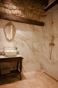 a bathroom with a sink and a mirror on the wall at La Petite Noble in Commentry