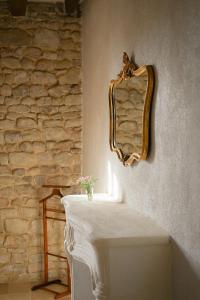 a mirror sitting on a wall next to a sink at La Petite Noble in Commentry