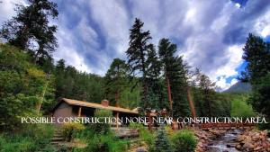 a house in the middle of a forest at The Inn on Fall River & Fall River Cabins in Estes Park