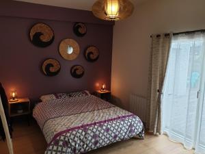 a bedroom with a bed and mirrors on the wall at Maison Fabien in Surzur