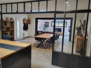 a dining room with a table and glass walls at Maison Fabien in Surzur