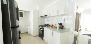 a white kitchen with a stove and a refrigerator at Apartament BC in San Cristóbal