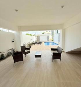 a living room with chairs and a table and a pool at Apartament BC in San Cristóbal