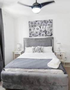 a bedroom with a bed with a love sign on the wall at Apartament BC in San Cristóbal +10 photos