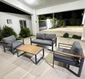 a patio with three chairs and a table and a couch at Apartament BC in San Cristóbal