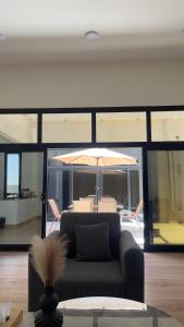 a living room with a couch and an umbrella at شاليه العهد Al Ahad in Badīyah