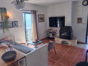 a living room with a couch and a tv at Holliday home Alida with jacuzzi in Podgora
