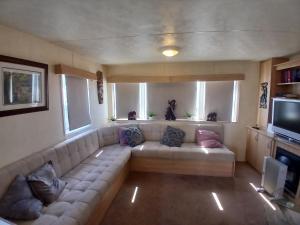 a living room with a couch and a television at Steeple Bay E68 in Steeple