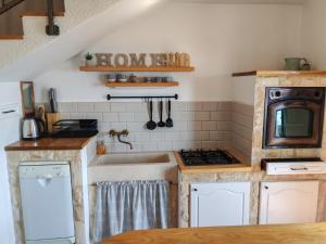 a kitchen with a sink and a stove at Holliday home Alida with jacuzzi in Podgora +18 photos