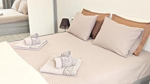 a bed with towels and pillows on it at Lux 2 Central Apartment with Garage in Plovdiv