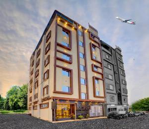 a building with an airplane flying in the sky at RedKEY Inn Hotel Bangalore Airport in Bangalore