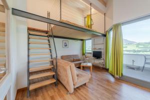 a tiny house with a loft bed and a living room at Residence Passerhaus in Schenna