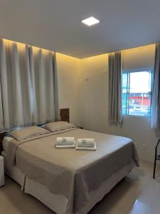a bedroom with a bed with two towels on it at Hotel Califórnia in Canindé