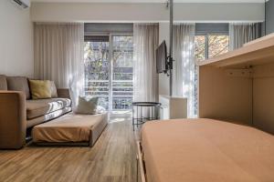 a room with a bed and a couch and a living room at Color Botánico in Buenos Aires