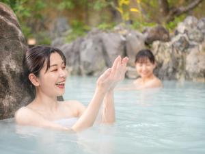 two women swimming in a pool of water at Kirishima Kokusai Hotel in Kirishima +134 photos
