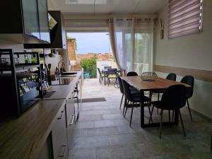 a kitchen with a table and chairs and a dining room at Nouveau ! Maison Dora 4-6 pers à St Pierre La Mer proche de la plage et de toutes commodités à pied in Saint Pierre La Mer