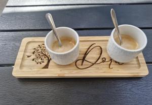 two cups of coffee on a wooden tray with spoons at Nouveau ! Maison Dora 4-6 pers à St Pierre La Mer proche de la plage et de toutes commodités à pied in Saint Pierre La Mer +27 photos