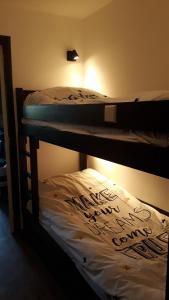 a bedroom with two bunk beds with writing on them at La Louvatière 28 in Mijoux