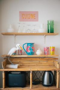 a shelf with cups and a sign that reads cuisine at Kuching in Arles