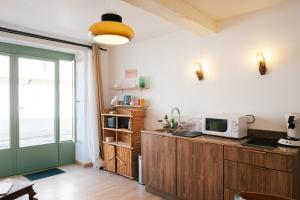 a kitchen with a microwave on top of a counter at Kuching in Arles