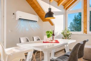a white dining room with a white table and chairs at Bright Lake View Apartment with Balcony and Air Conditioning in Tutzing
