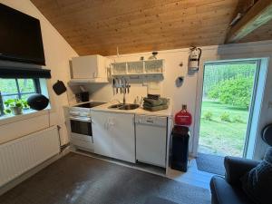 a kitchen with a sink and a stove in a caravan at Stubbhuggets Lillstuga in Trosa