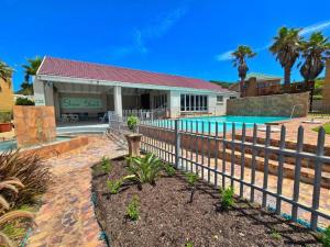 a house with a fence and a swimming pool at Myoli Beach Breeze in Sedgefield