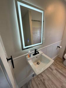 a bathroom with a white sink and a mirror at Sun2Sand Beach House in Salisbury +17 photos