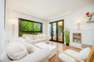a living room with white furniture and a fireplace at Ana Playasol in Port d'Alcudia