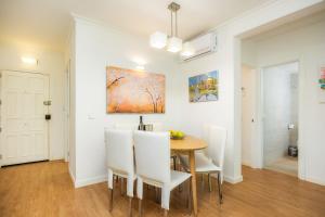a dining room with a wooden table and white chairs at Ana Playasol in Port d'Alcudia