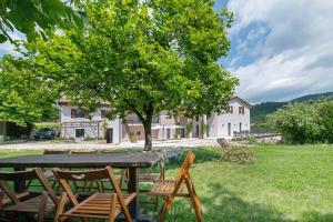 a table and chairs in a yard with a tree at Agriturismo Cascina Capo in Negrar