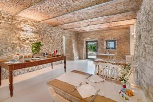 a room with a stone wall and a table and chairs at Agriturismo Cascina Capo in Negrar