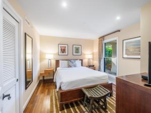 a bedroom with a bed and a window and a tv at 3-Bed Villa 115 at Turtle Bay in Kahuku +45 photos