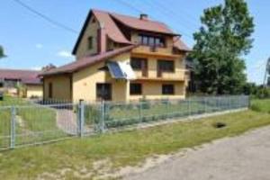 a house with a fence in front of it at 9 Dańce - comfortable accommodation 22-220 - WIFI included in Dańce