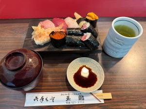 a tray of sushi and a cup of tea on a table at Haniwa Stay Josai in Nagoya