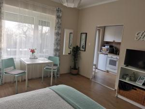 a bedroom with a bed and a table and chairs at CASA MINI 5 in Pécs