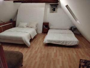 two beds sitting in a room with a staircase at Grand Duplex 9 pers-Centre de La Bourboule in La Bourboule