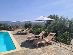 a group of chairs and umbrellas next to a swimming pool at Quinta Alto da Fraga in Vila Nova de Foz Coa