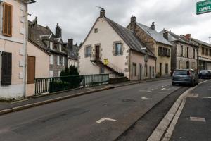 a street with houses and a car parked on the road at Grand Duplex 9 pers-Centre de La Bourboule in La Bourboule
